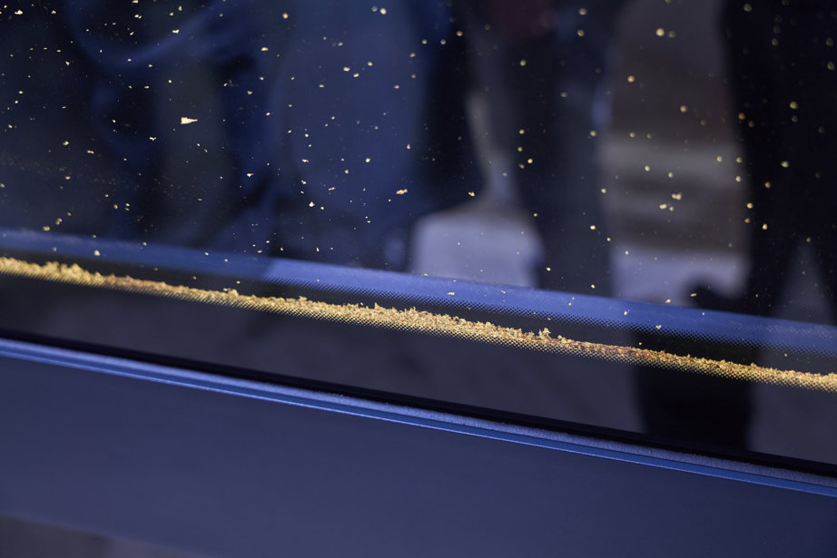 Gold flakes inside Water-filled Glass