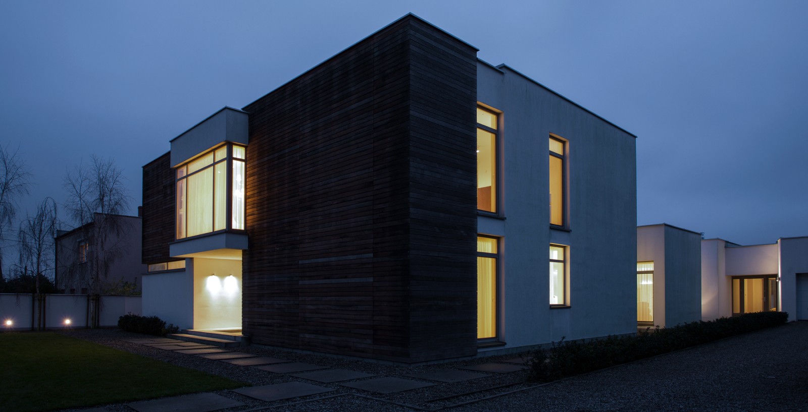 Night exterior of a house with warm light from windows